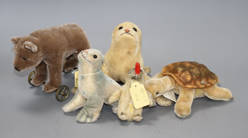 A 1960s Steiff Robby sea lion, another similar larger sea lion, a penguin, a turtle and a more recent bear on wheels